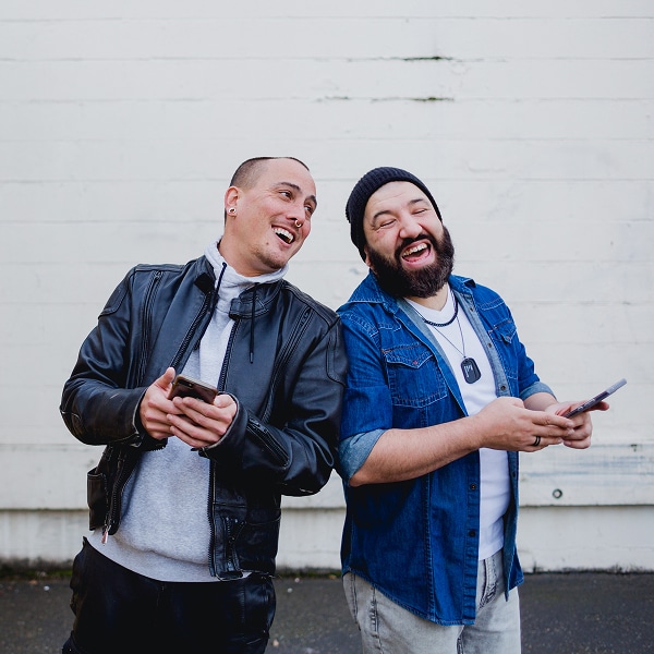two people holding phones and smiling